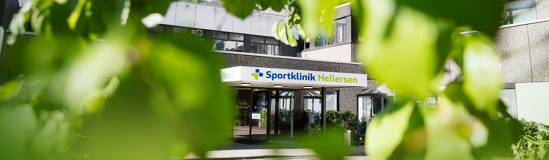Aufnahme des Haupteingangs der Sportklinik Hellersen aus der Perspektive der umgebenden Natur